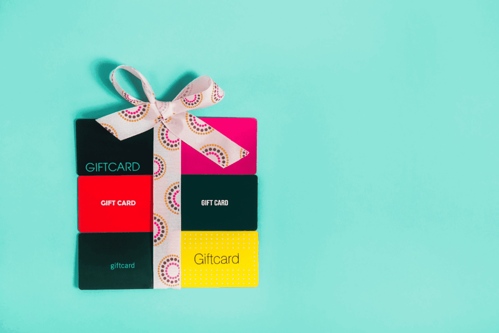 Assorted colorful gift cards tied with a ribbon on a teal background