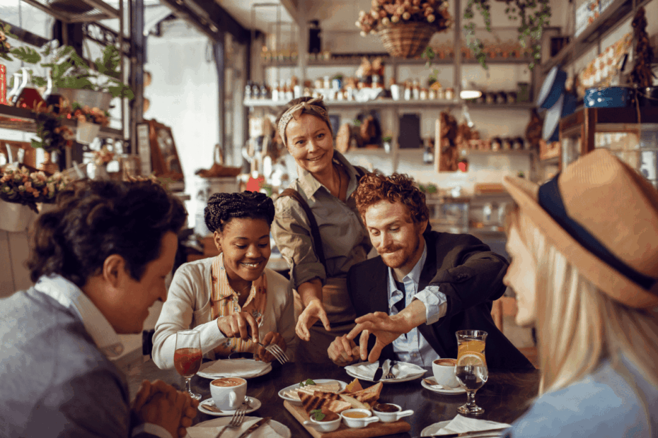 Group of friends dining together at a cozy restaurant with a smiling server