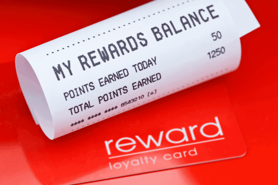 Receipt showing reward points balance placed on top of a red loyalty card.