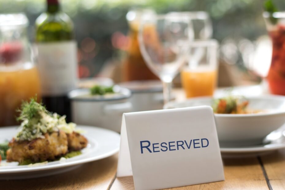Restaurant table with a reserved sign, plated food, and drinks