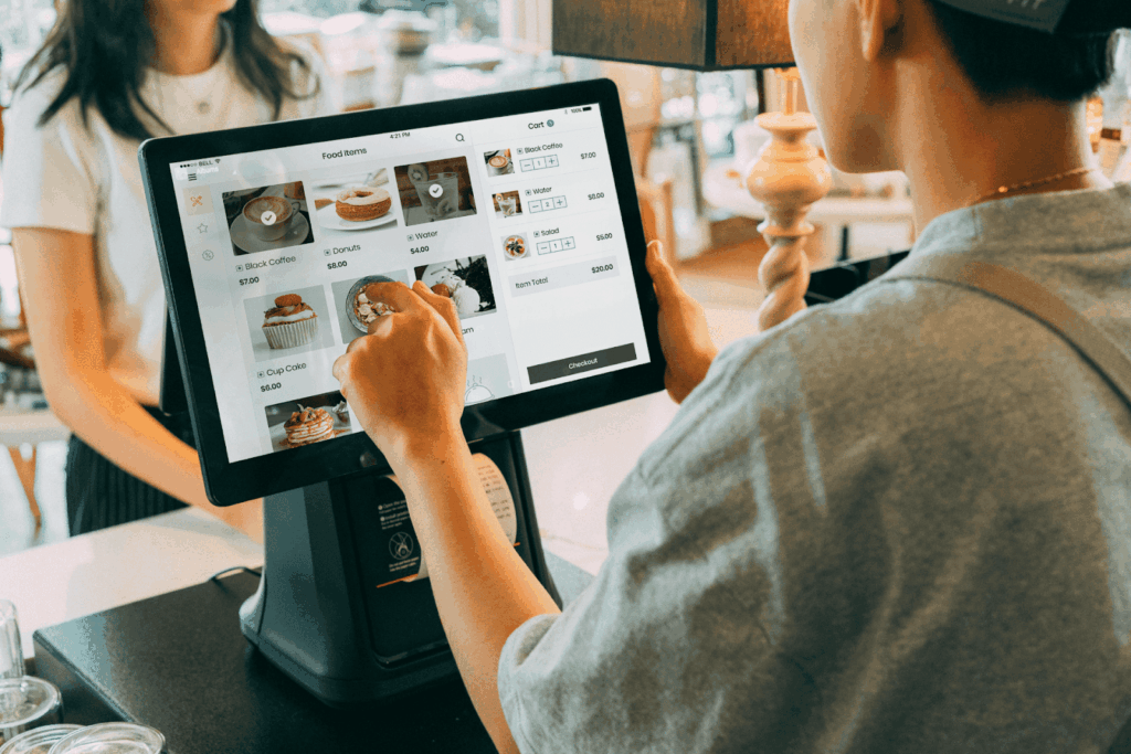 Café employee using a touchscreen POS system to take an order.