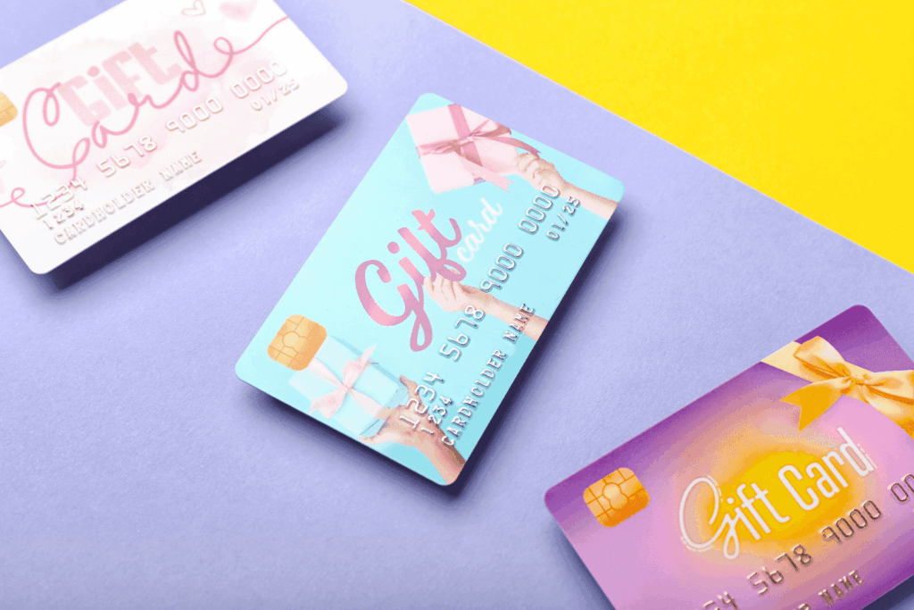 Colorful gift cards with ribbon designs placed on a purple and yellow background.