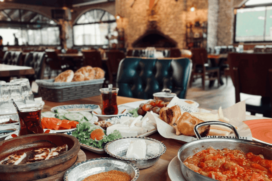 A table filled with assorted dishes and tea in a cozy restaurant setting.
