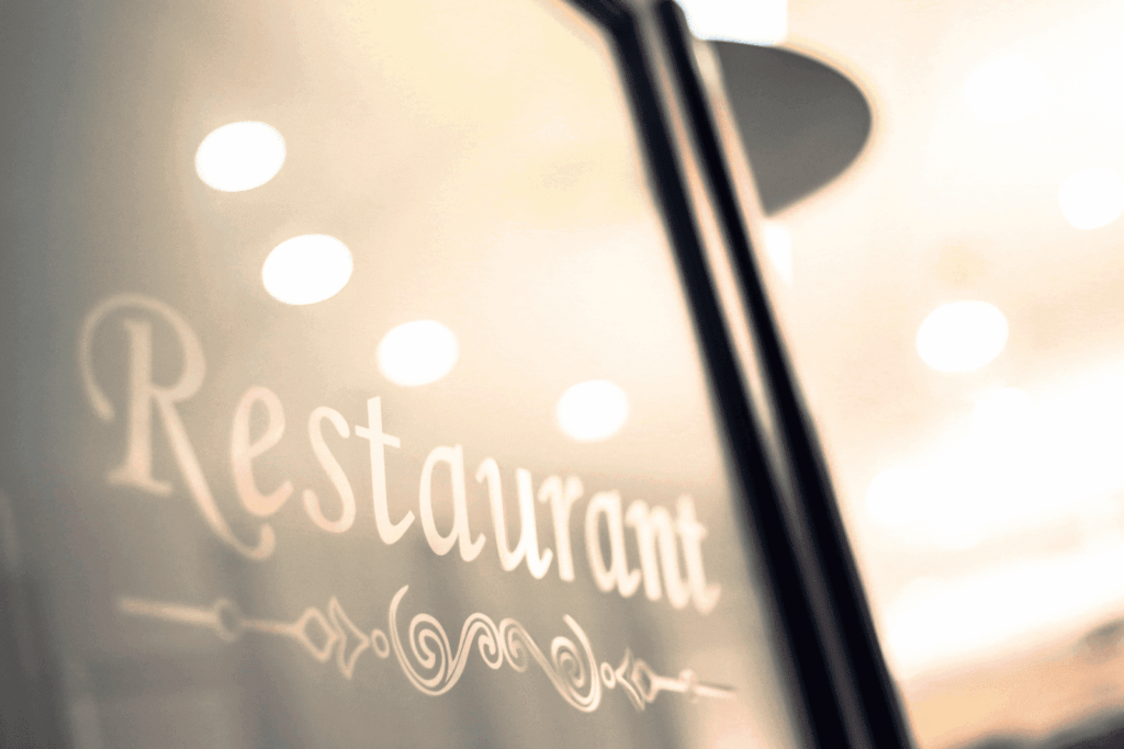 Close-up of a glass door with the word “Restaurant” written in decorative script