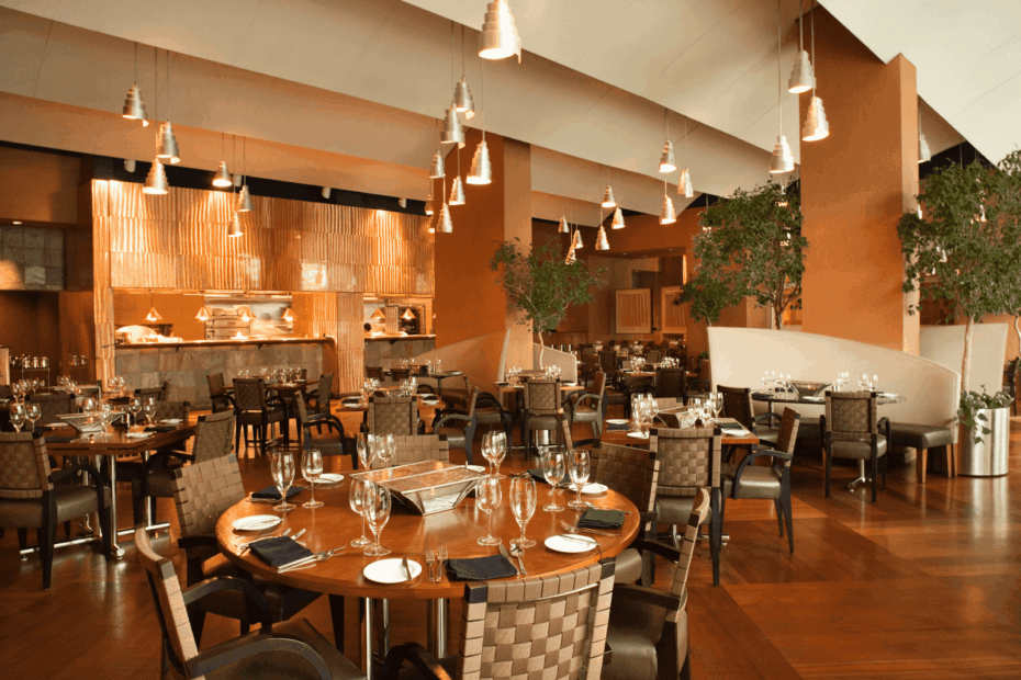 Elegant restaurant dining room with set tables, warm lighting, and modern decor.