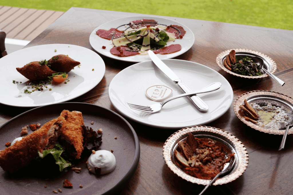Table filled with assorted appetizers and plated dishes at a restaurant.